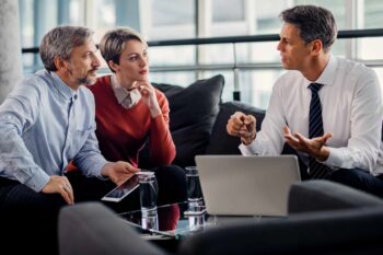 Financial Advisor Using Laptop And Communicating With A Couple During The Meeting In The Office.